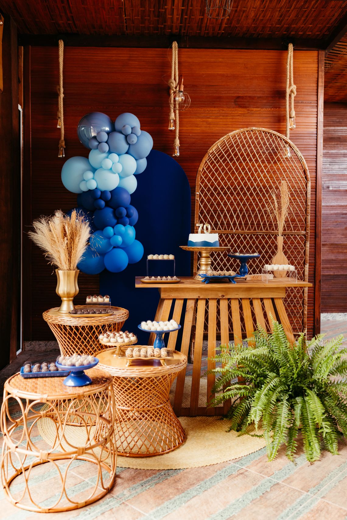Stylish milestone birthday setup with blue balloons, desserts, and coordinated party decor