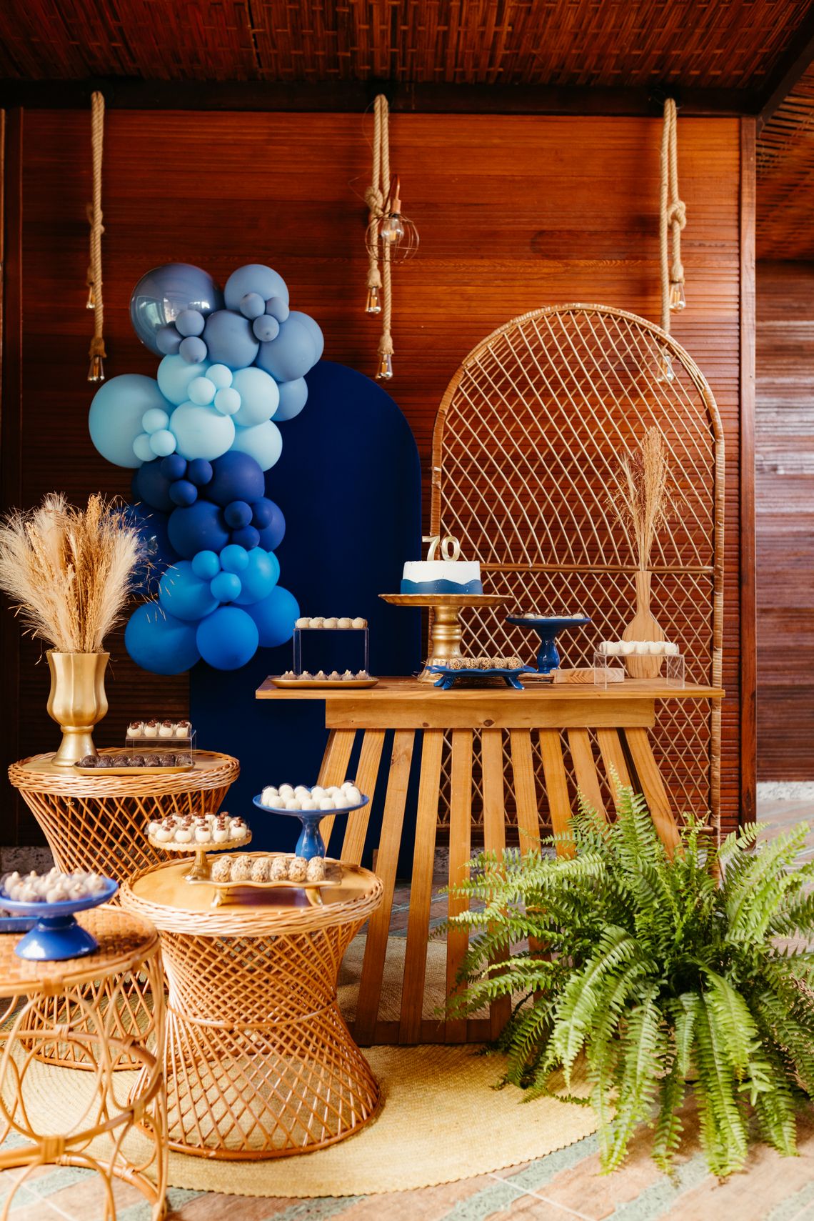 Elegant milestone birthday celebration table with balloons, cake, flowers, and event styling