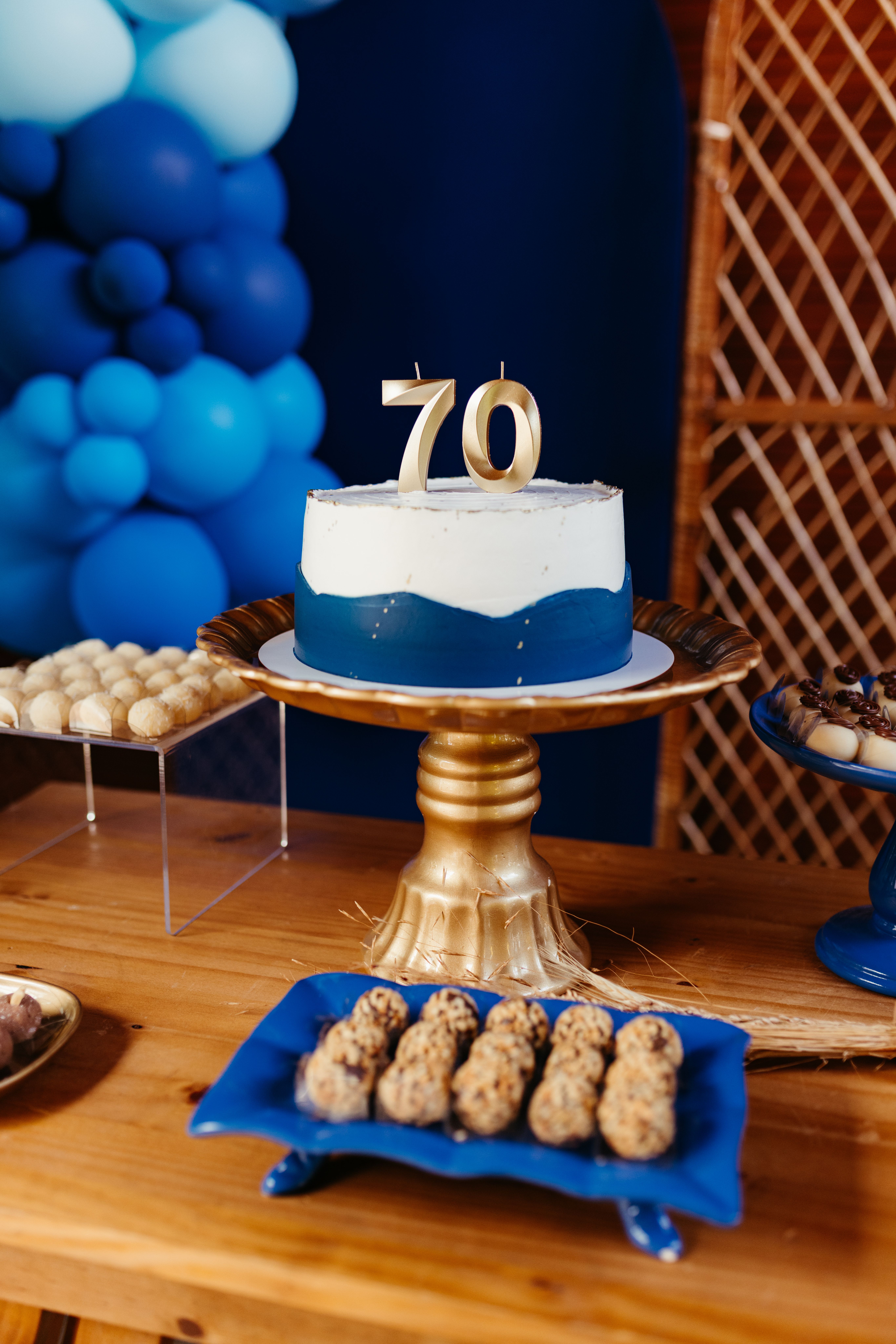 A beautifully decorated cake and treats for a 70th birthday celebration with vibrant blue hues.