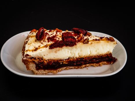 Indulge in a creamy cheesecake slice topped with pecans and red berries. Perfect dessert image.