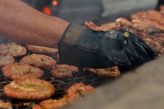 A chef grills traditional meats over an open flame at a BBQ in Buenos Aires, Argentina.