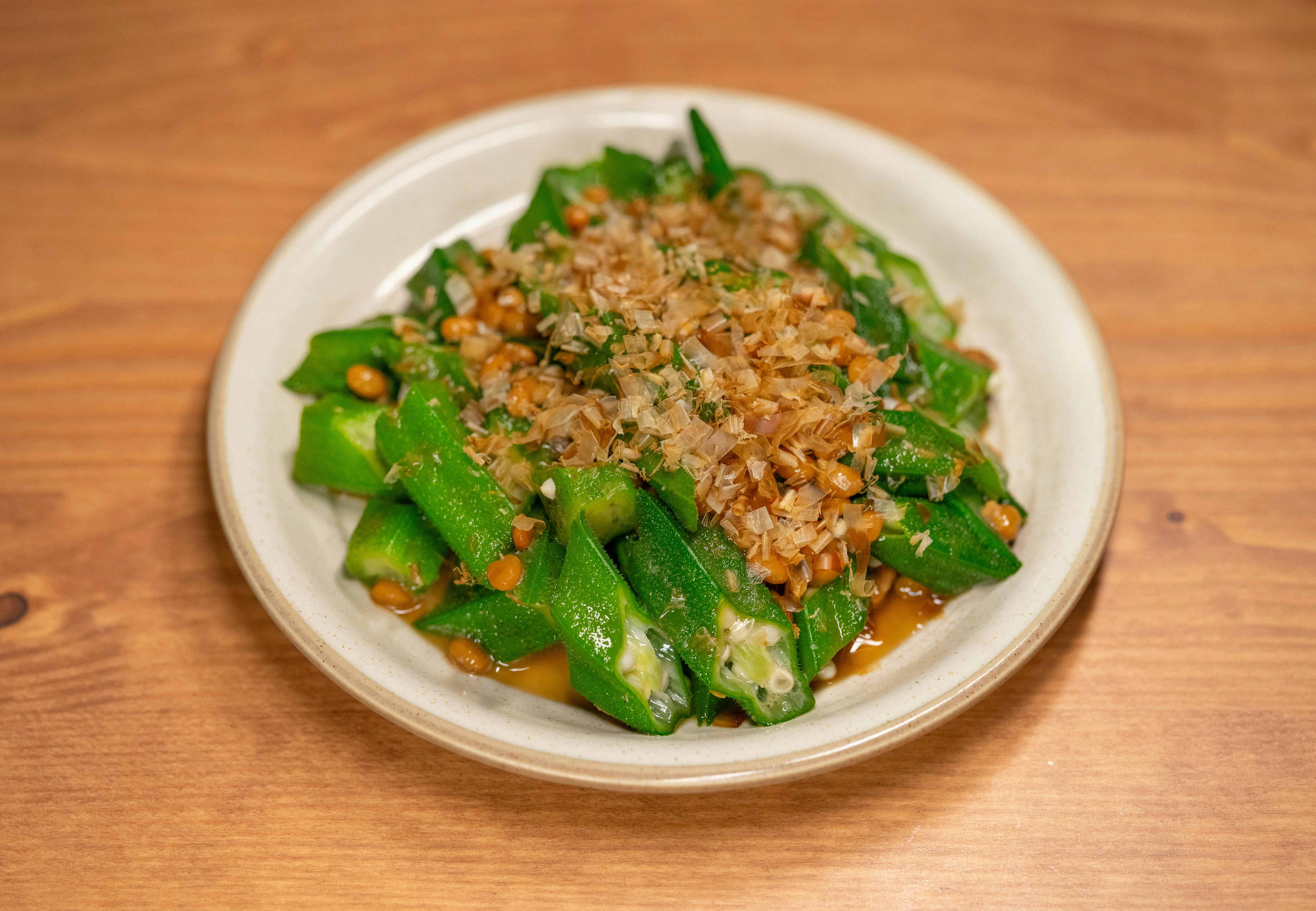 Savory plate of okra and natto topped with bonito flakes, perfect for Asian cuisine lovers.