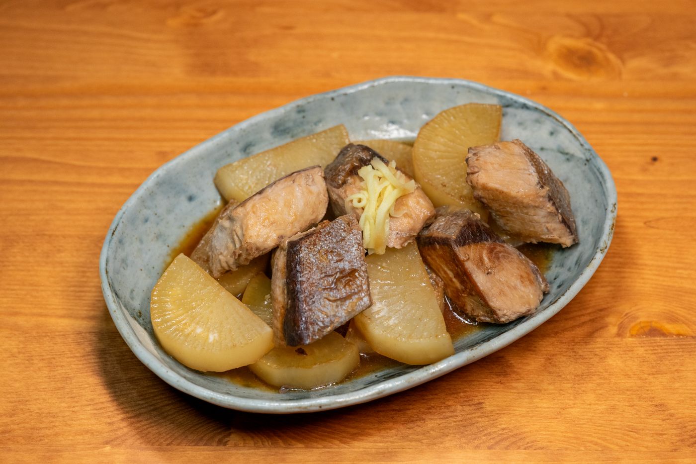 和皿に盛られた魚と大根の煮物