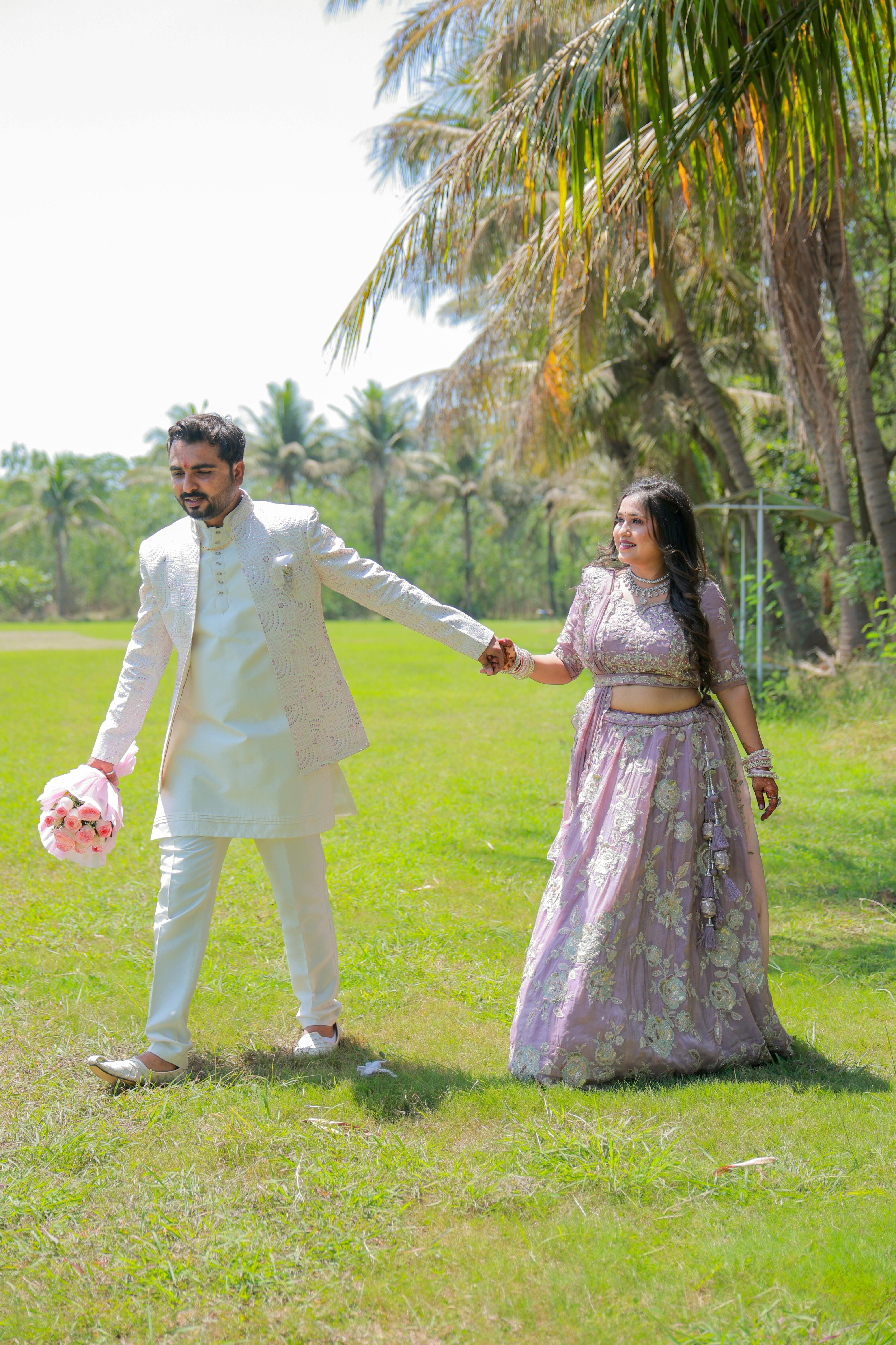 A couple enjoys a romantic outdoor wedding photoshoot wearing traditional attire.