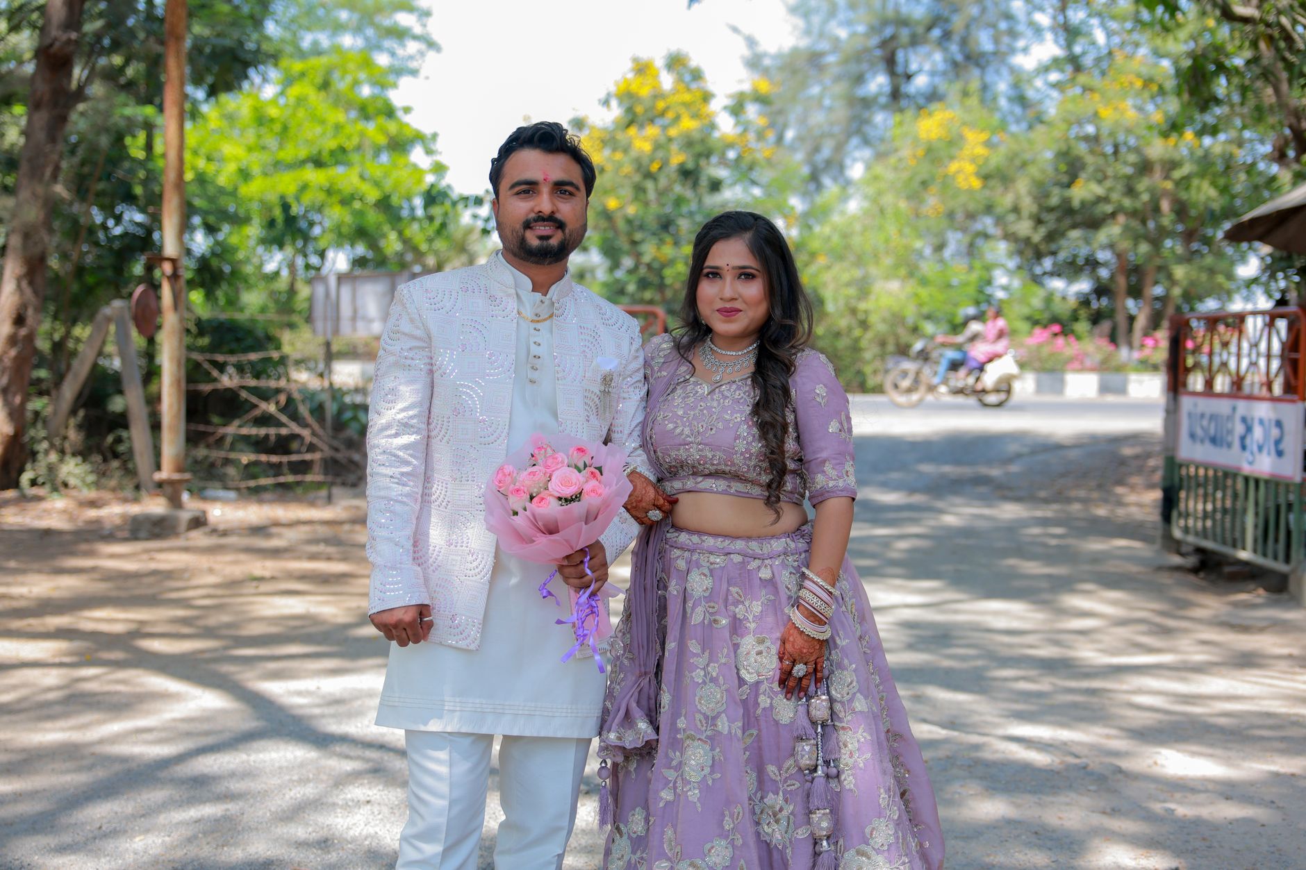 Charming couple in traditional attire outdoors, embracing love in a serene setting.