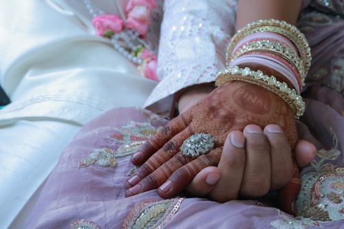 Free Close-up of a couple's hands adorned with henna and jewelry, symbolizing love and unity in an Indian wedding. Stock Photo