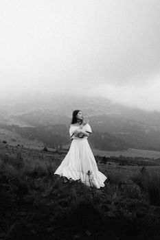 A woman in a flowing dress stands in a foggy field in State of Mexico, exuding a serene and ethereal vibe.