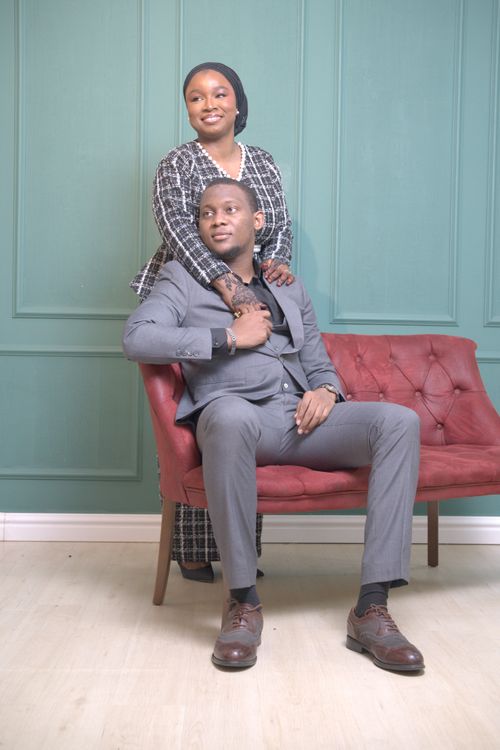 Free A sophisticated couple poses in a chic, indoor setting with stylish attire and elegant demeanors. Stock Photo