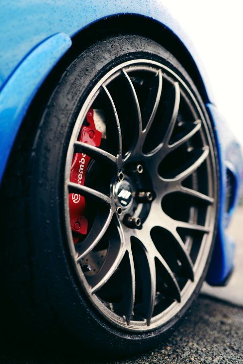 Free A close-up shot of a car wheel with a detailed view of the Brembo brake system on a blue sports car. Stock Photo
