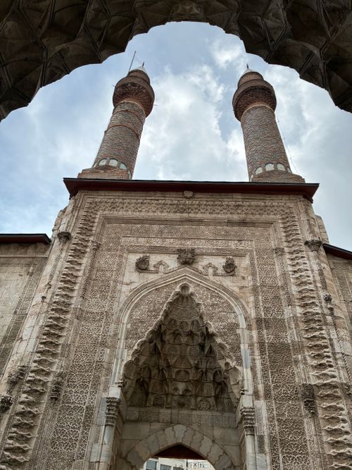 Free Majestic view of the historic Double Minaret Madrasa in Sivas, showcasing intricate stonework and towering minarets. Stock Photo
