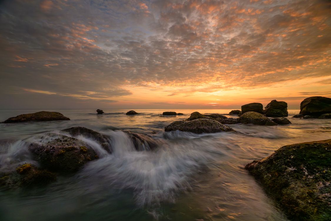 Captivating Ocean Sunset with Rocky Shoreline · Free Stock Photo