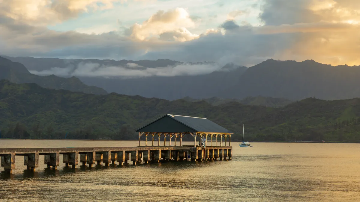 Hanalei Pier with the green mountains of Kauai's North Shore behind it