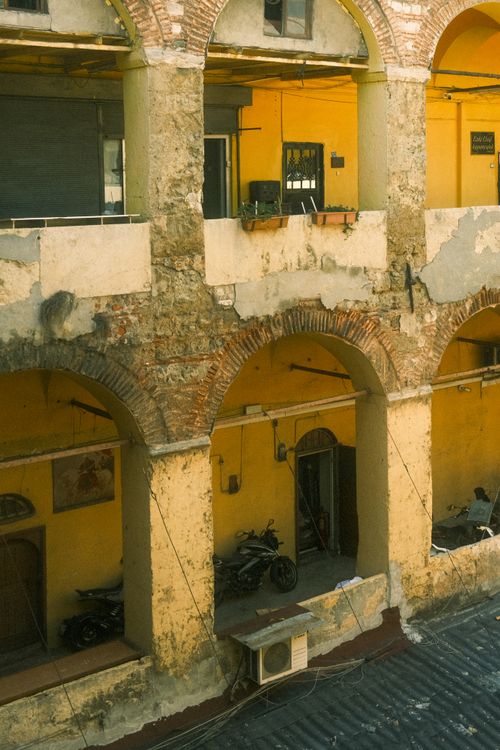 Free Aged arches and vibrant walls of a courtyard in İstanbul showcase historical architecture. Stock Photo