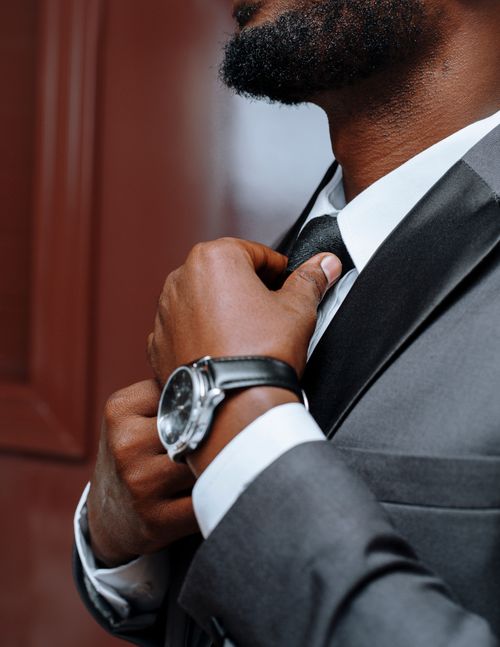 Free Close-up of a businessman adjusting his black tie. Perfect for corporate themes and fashion concepts. Stock Photo