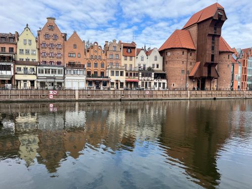 Free Beautiful reflection of historic Gdańsk architecture along the Motława River on a clear day. Stock Photo