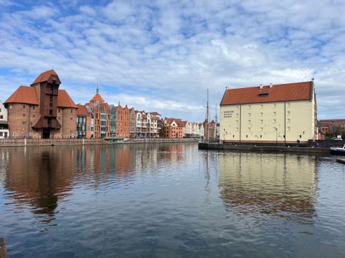 Free Beautiful Gdańsk waterfront with historical buildings and reflections under blue skies. Stock Photo