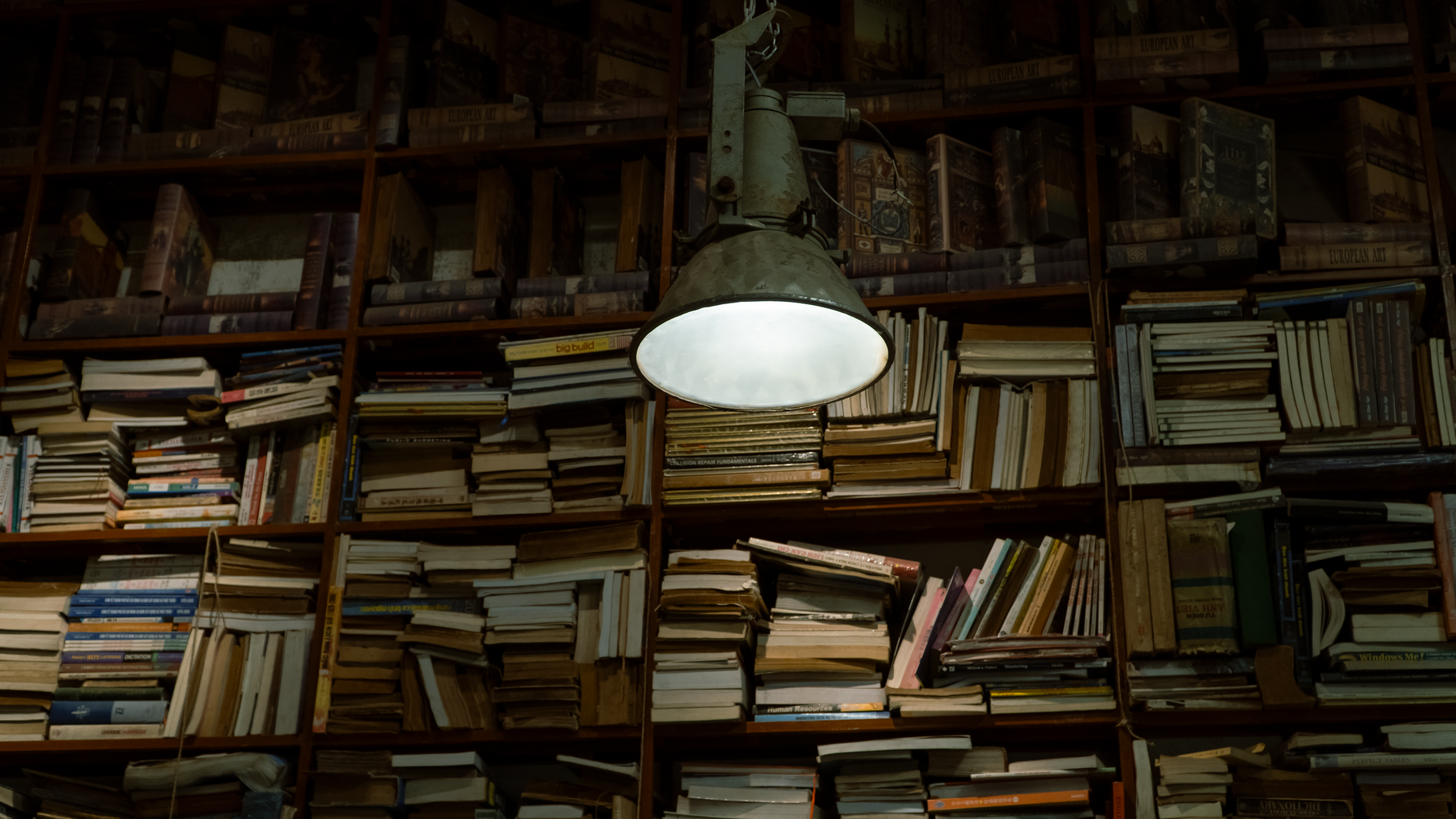 Cozy vintage library setting with books and a retro lamp.