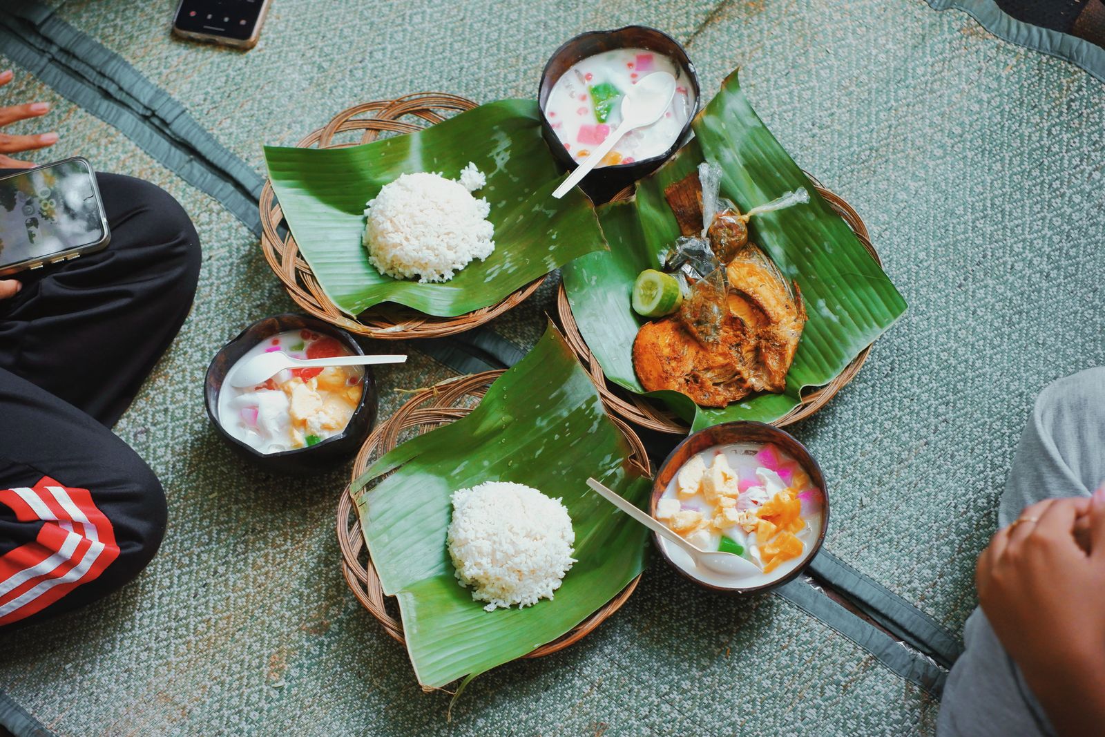 Enjoy a traditional Indonesian meal featuring rice, fish, and desserts served on banana leaves.