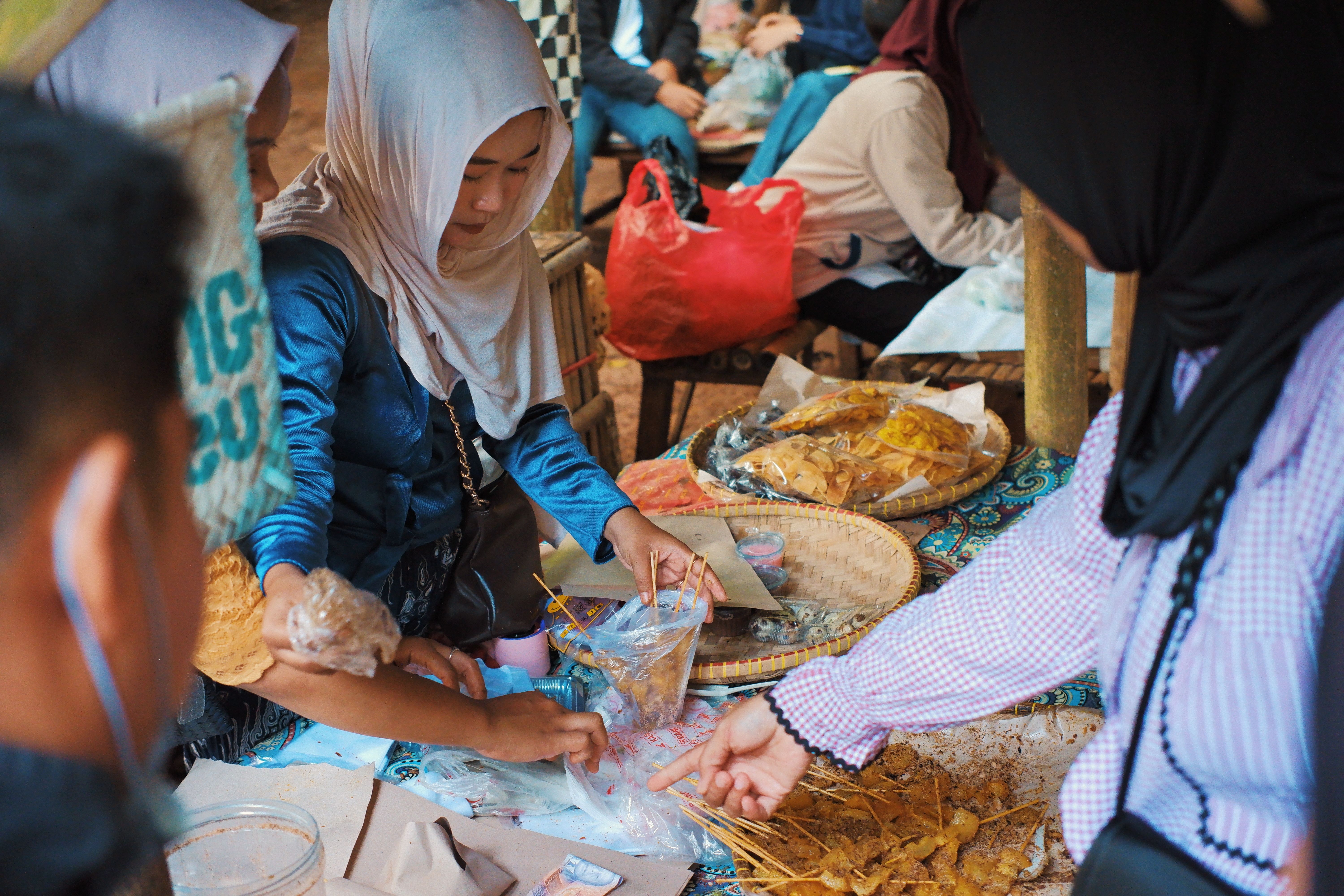 A lively market in West Java with locals selling traditional Indonesian snacks and goods.