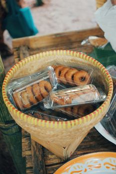 Plastic-packaged donuts displayed in a bamboo basket at a market stall in Jawa Barat, Indonesia. - Fotografer Sidoarjo