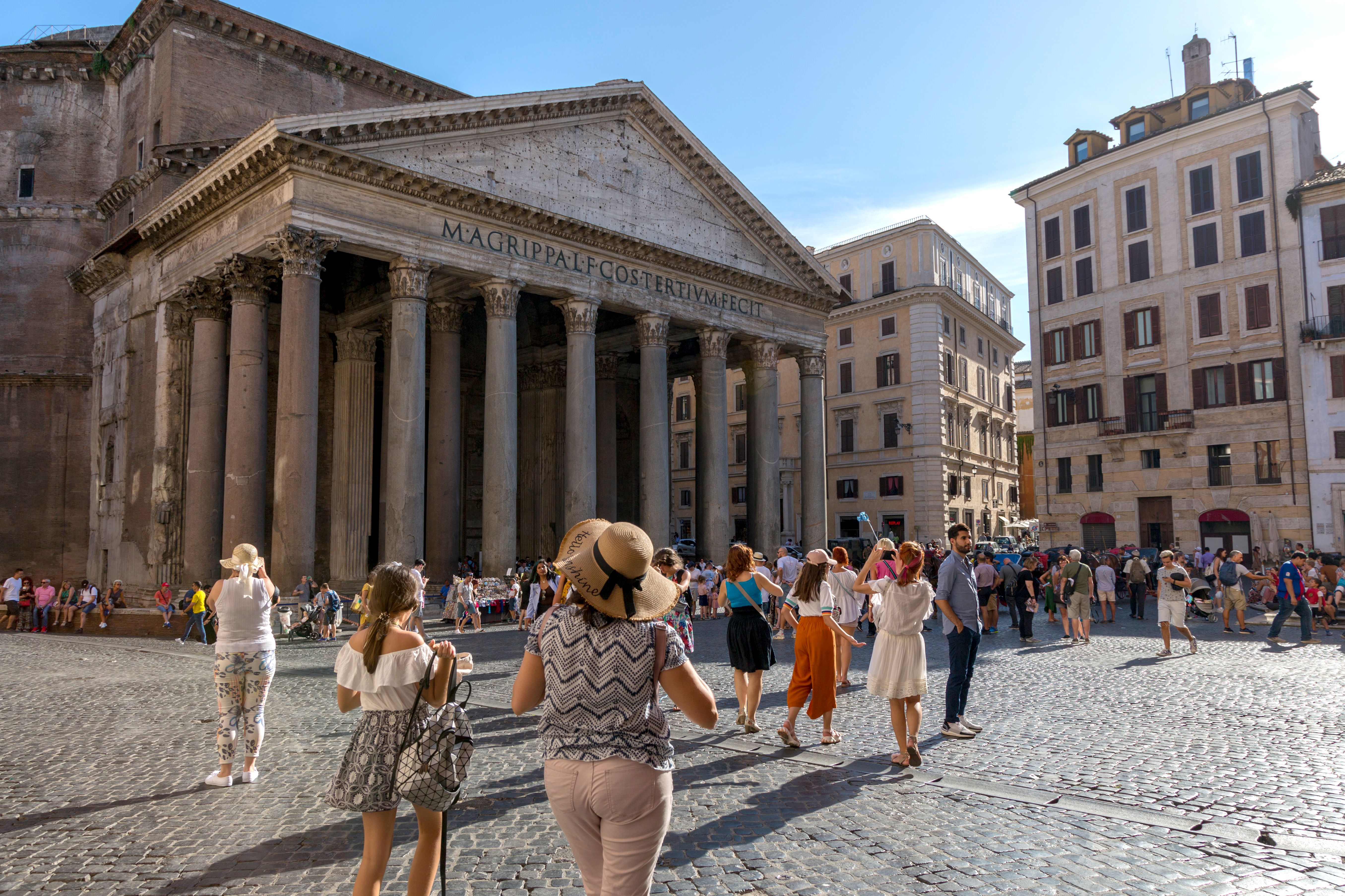 Tourists gather outside the Pantheon in Rome on a bright, sunny day