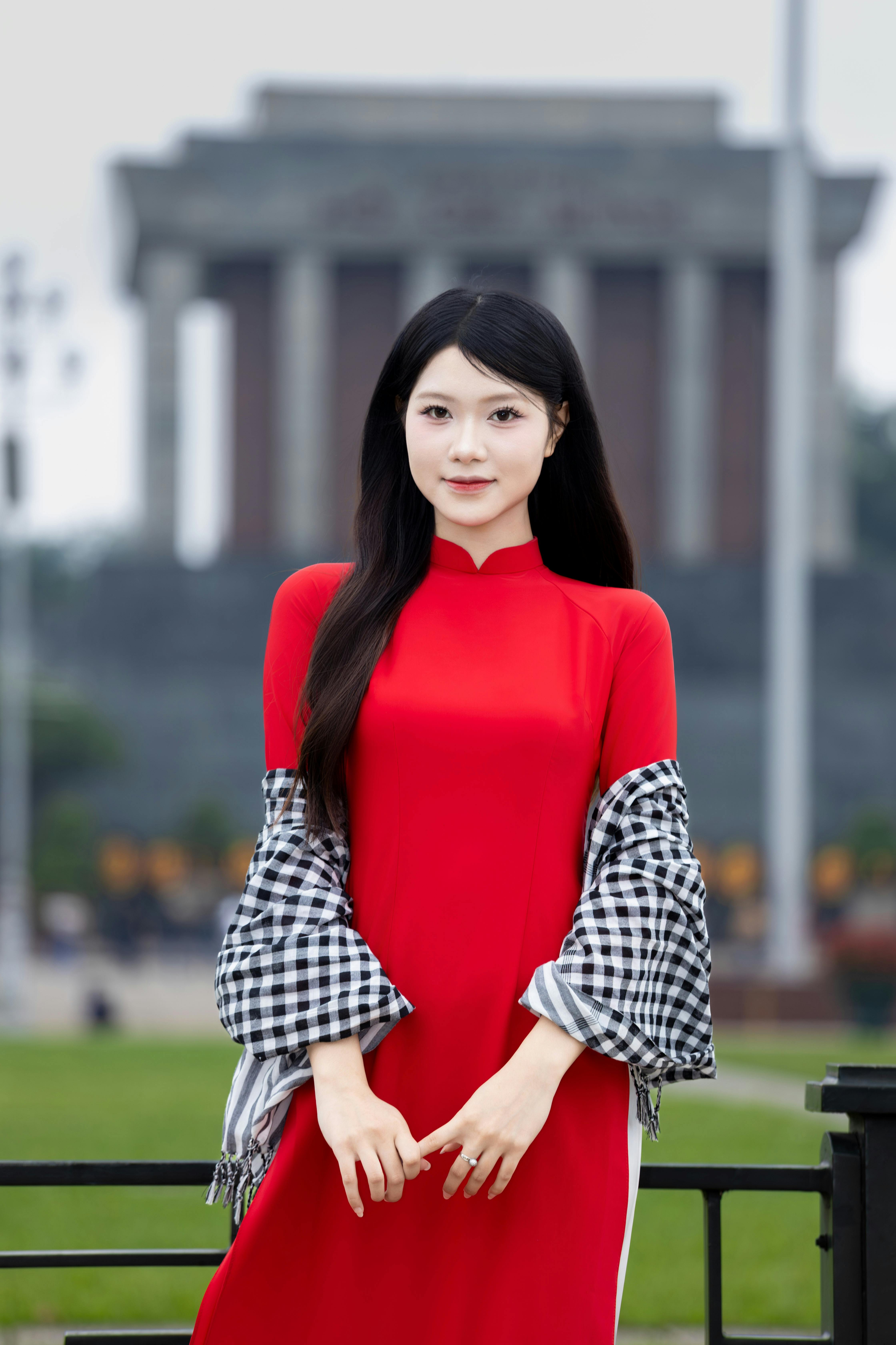 A Vietnamese woman in a vibrant red ao dai at the Ho Chi Minh Mausoleum, Hà Nội.