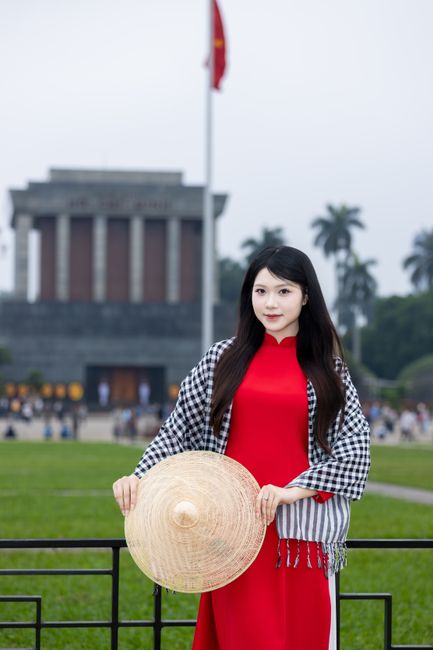 Vietnamese woman wearing ao dai and non la in front of Ho Chi Minh Mausoleum, Hanoi.