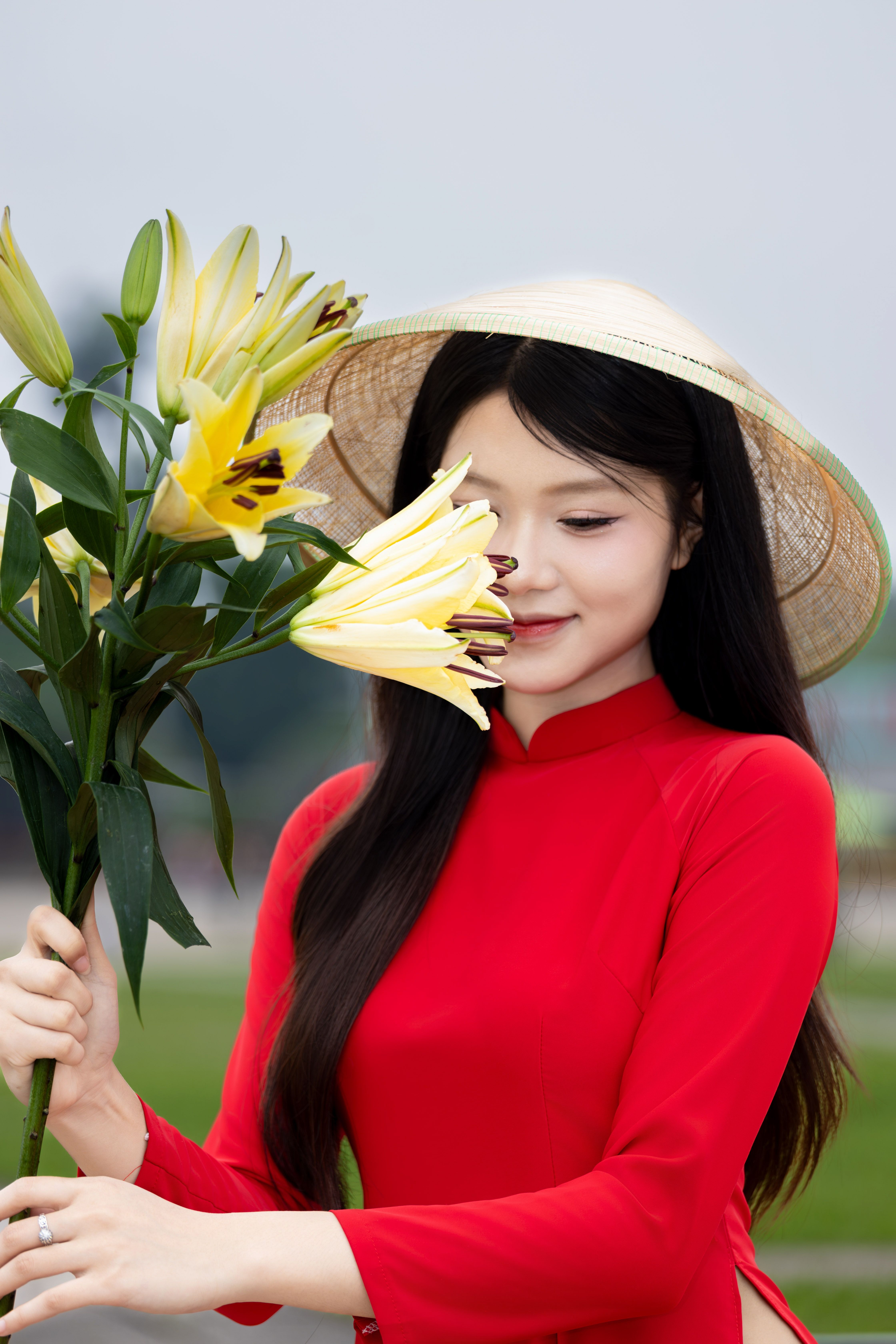Vietnamese Woman in Ao Dai Smelling Lilies