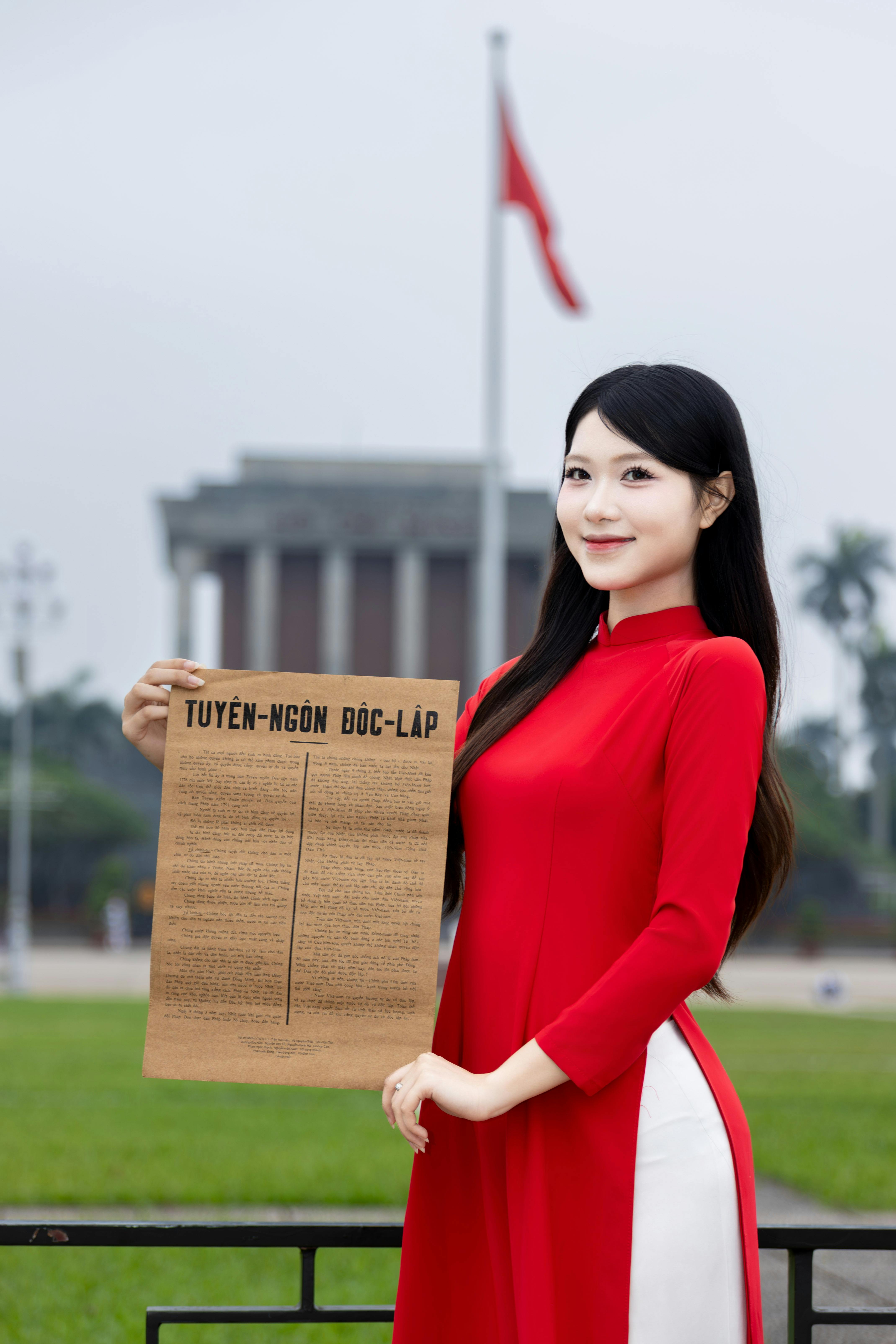 Woman holding Vietnam's Declaration of Independence near Ho Chi Minh Mausoleum, Hanoi.