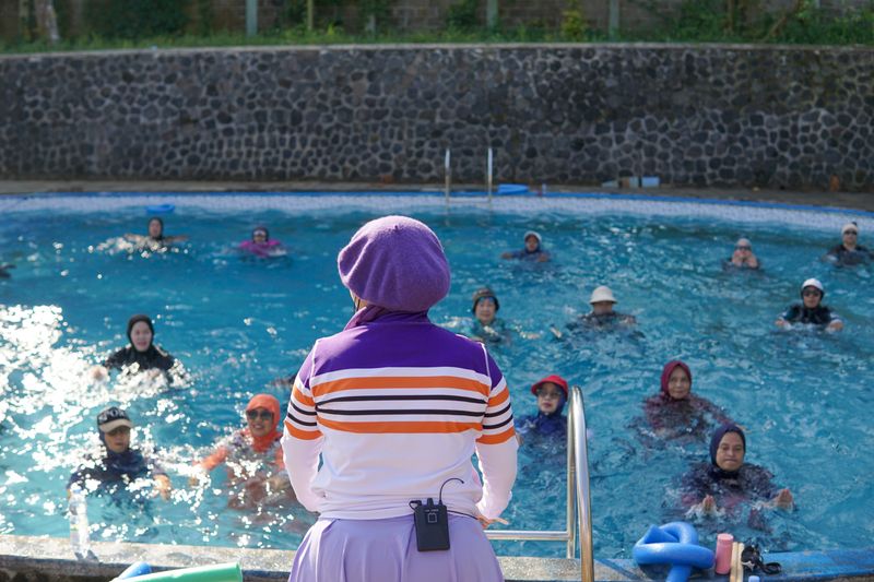 Clase grupal de natación guiada por un instructor