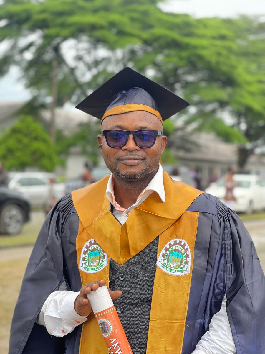 African graduate celebrating in cap and gown