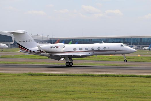A private jet touches down smoothly on an airport runway, showcasing aviation precision.