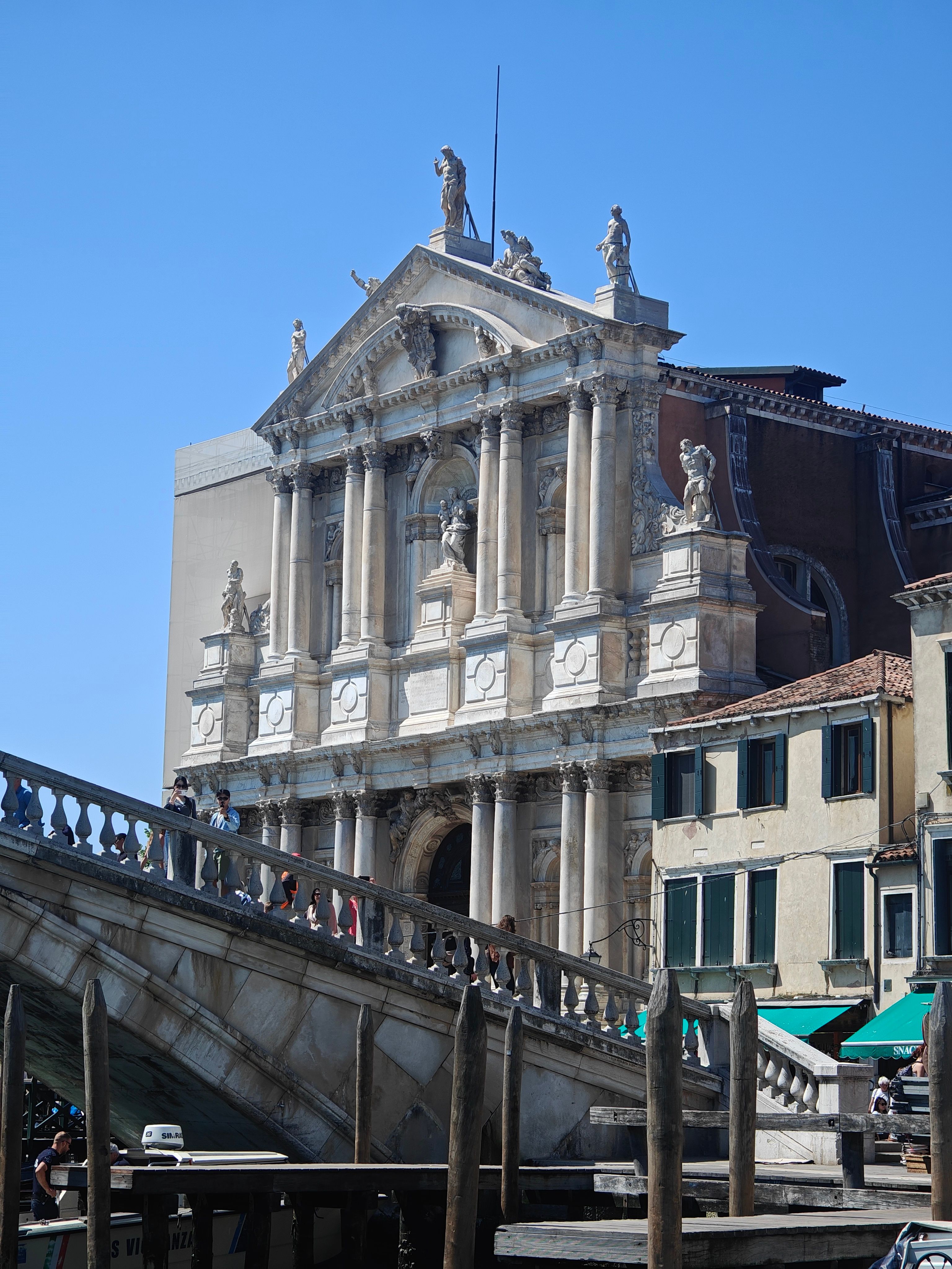 Baroque architecture of Venice's Scuola Grande di San Rocco under clear blue sky.