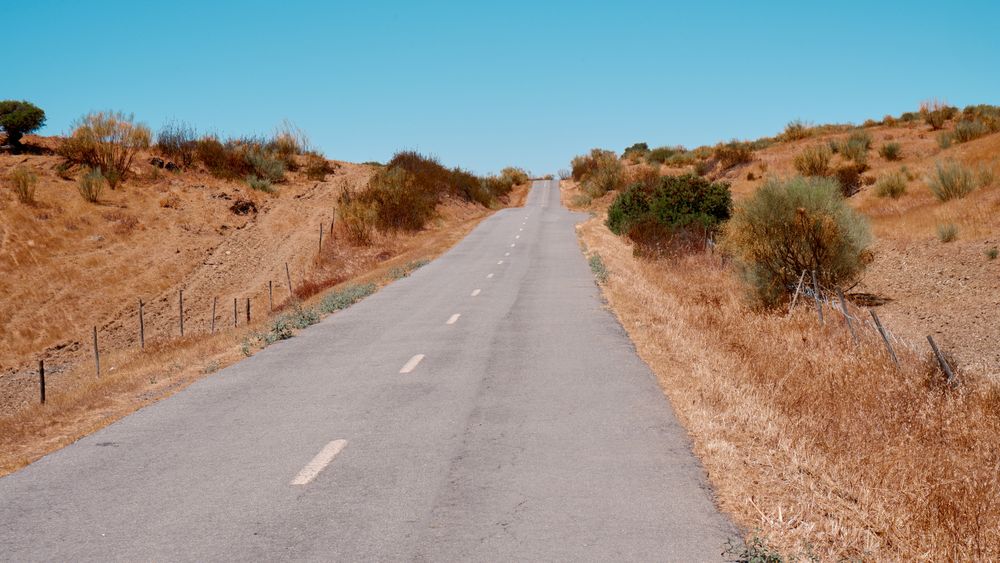 Drum deschis traversând un peisaj uscat și rar populat din Portugalia