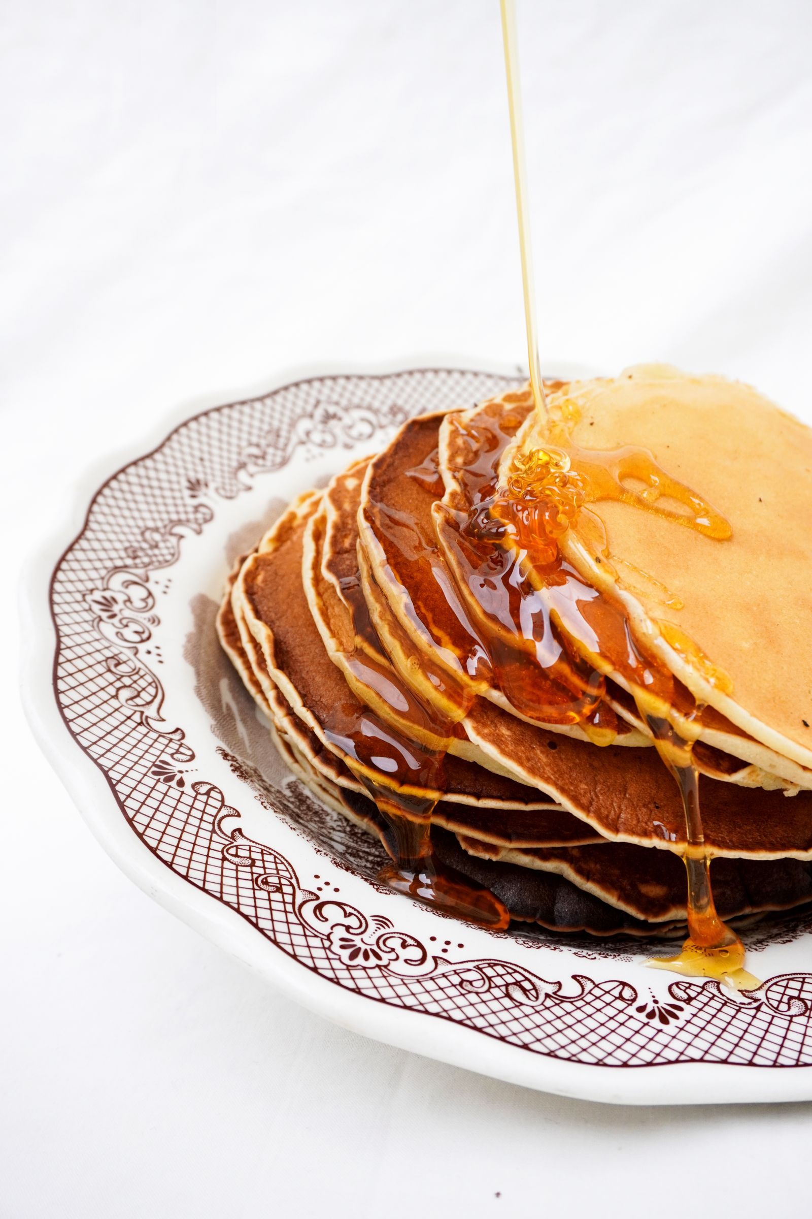 Stack of golden pancakes drizzled with maple syrup