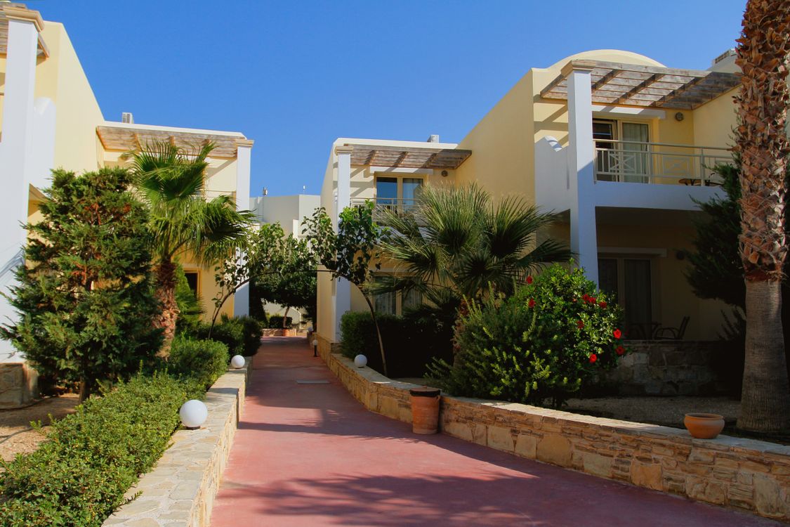 Mediterranean Style Villas Surrounded by Lush Palm Trees · Free Stock Photo