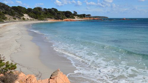 Free Serene beach scene with clear waters and rocky coastline in Porto-Vecchio, Corsica. Stock Photo