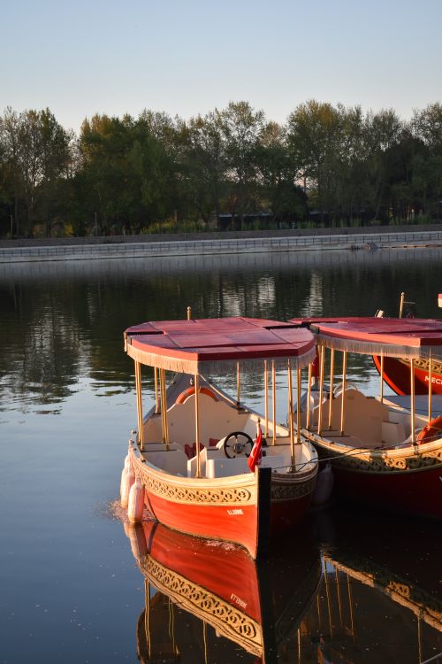 Free Red boats reflected on Meriç River in Edirne, Türkiye during a serene day. Stock Photo