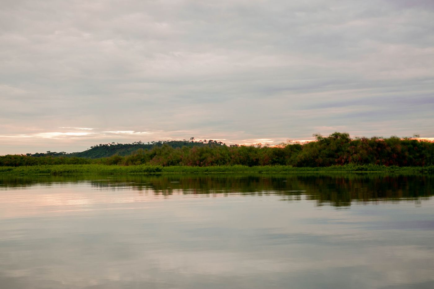 Illustrative stock photograph: Lake at sunset with green shoreline