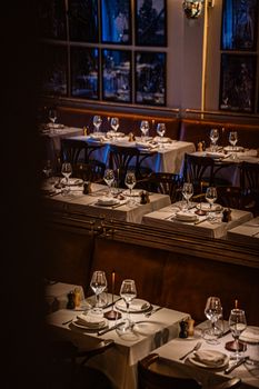Warmly lit upscale restaurant with neatly arranged tables and elegant glassware.