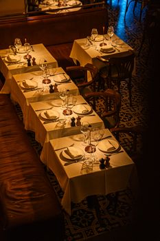 Warmly lit restaurant tables with elegant settings, creating a cozy and inviting dining ambiance.