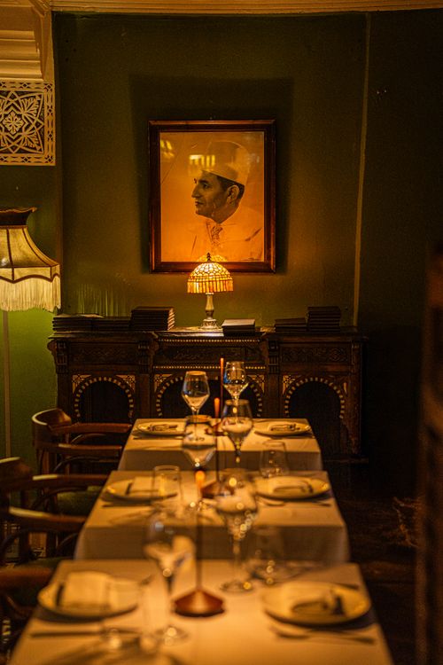 Free Warmly lit dining room featuring elegant table settings and vintage decor, perfect for a cozy atmosphere. Stock Photo