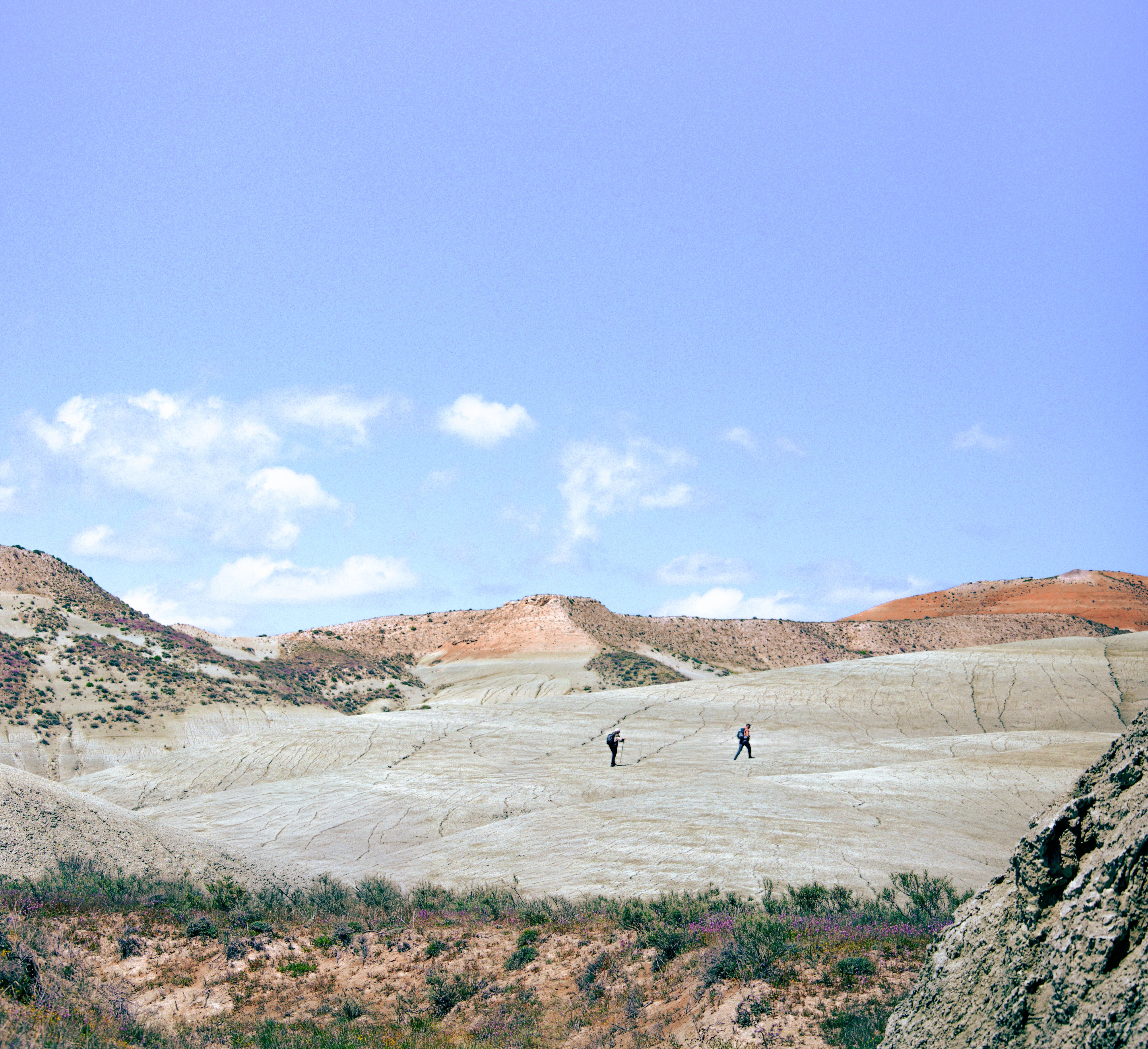 Hikers Exploring Arid Desert Landscape · Free Stock Photo