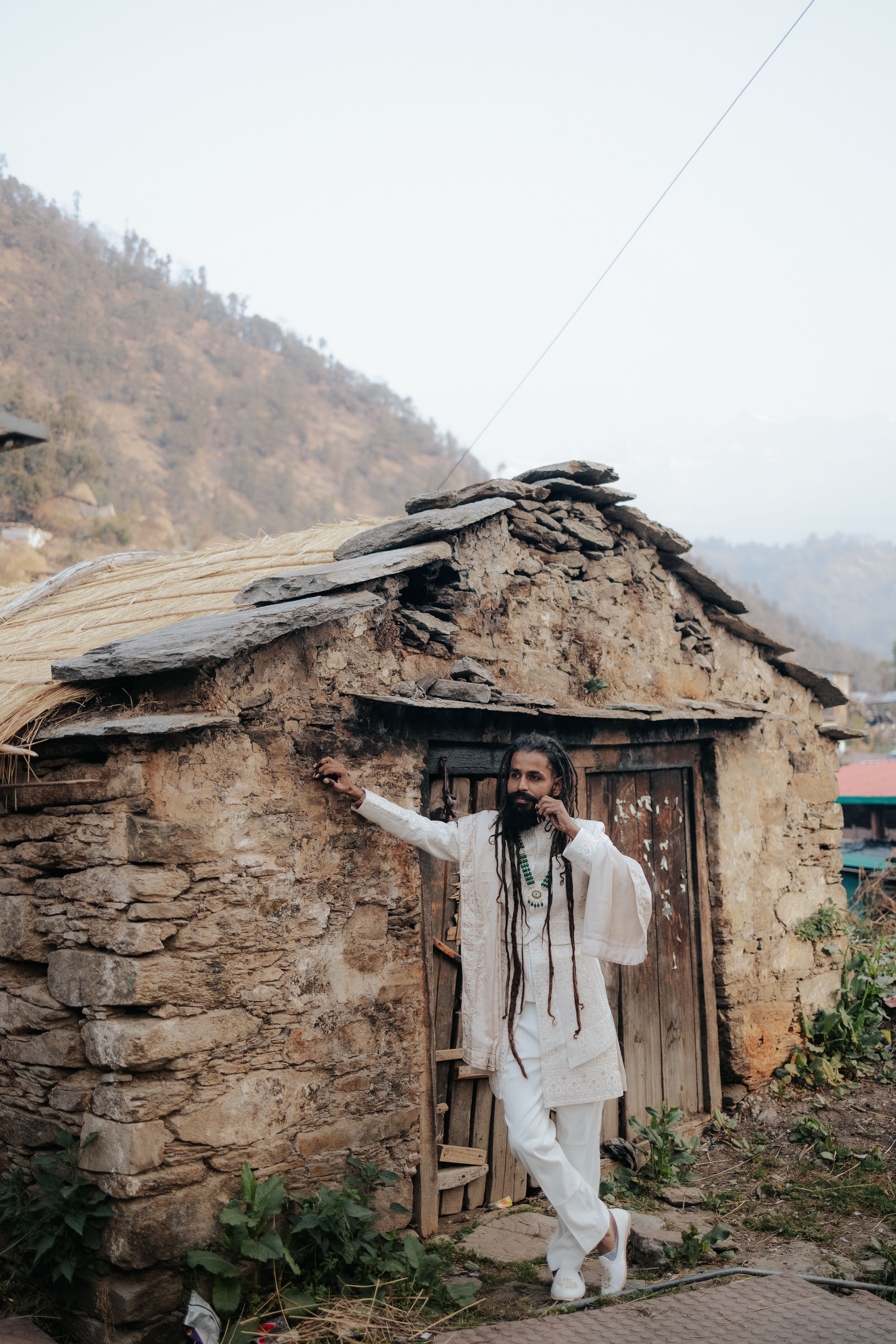 Man in Traditional Dress by Rustic Stone Hut · Free Stock Photo