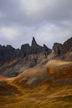 Breathtaking view of a rugged mountain range with dramatic clouds above.