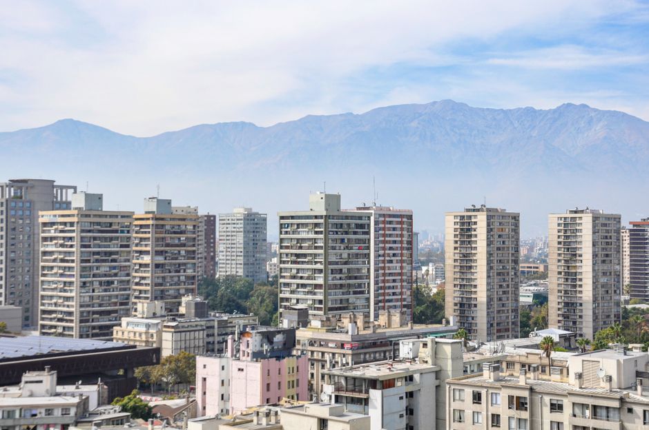 Santiago city view with modern skyscrapers and Andes Mountain backdrop.