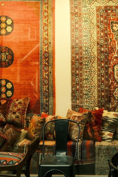 Free A cozy display of vintage oriental rugs and cushions in a stylish store setting. Stock Photo