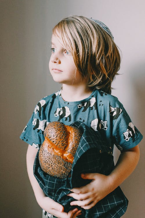 Boy In Blue Crew Neck T-shirt Holding A Bread
