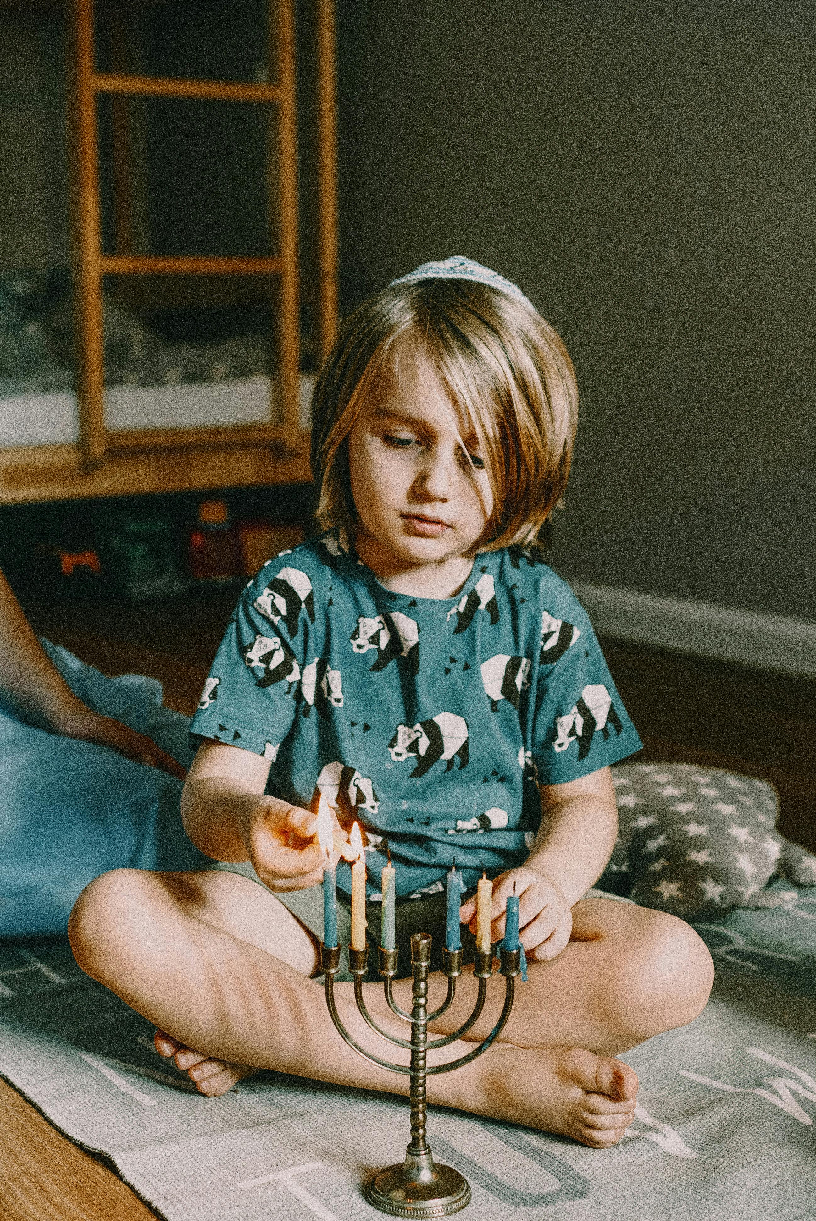 boy lighting menorah