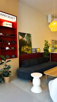 Stylish café interior featuring cozy seating and a selection of hats for sale.